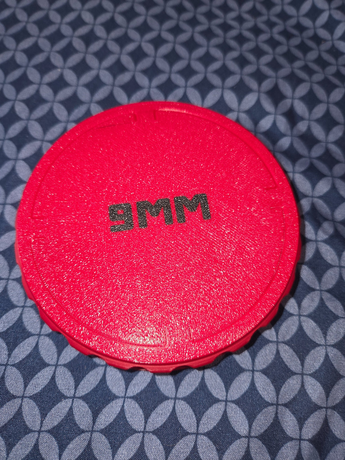 Red 3D-printed 9mm bullet puck with black 9MM lettering